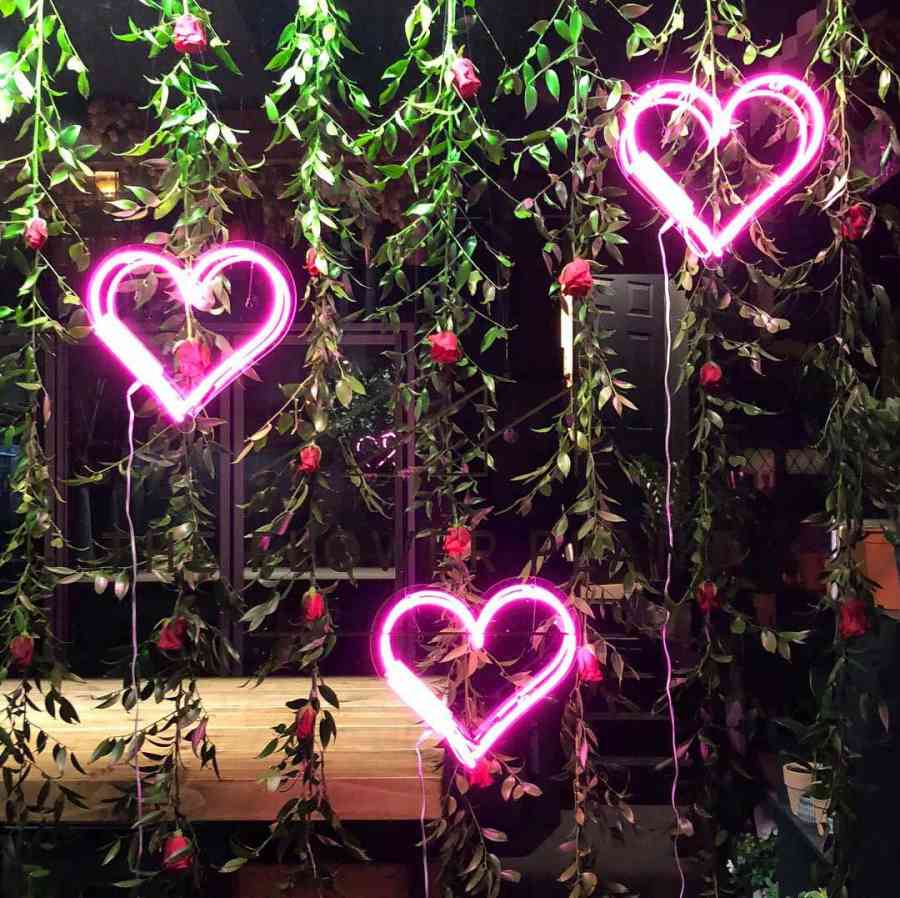 Pink neon hearts and hanging red roses