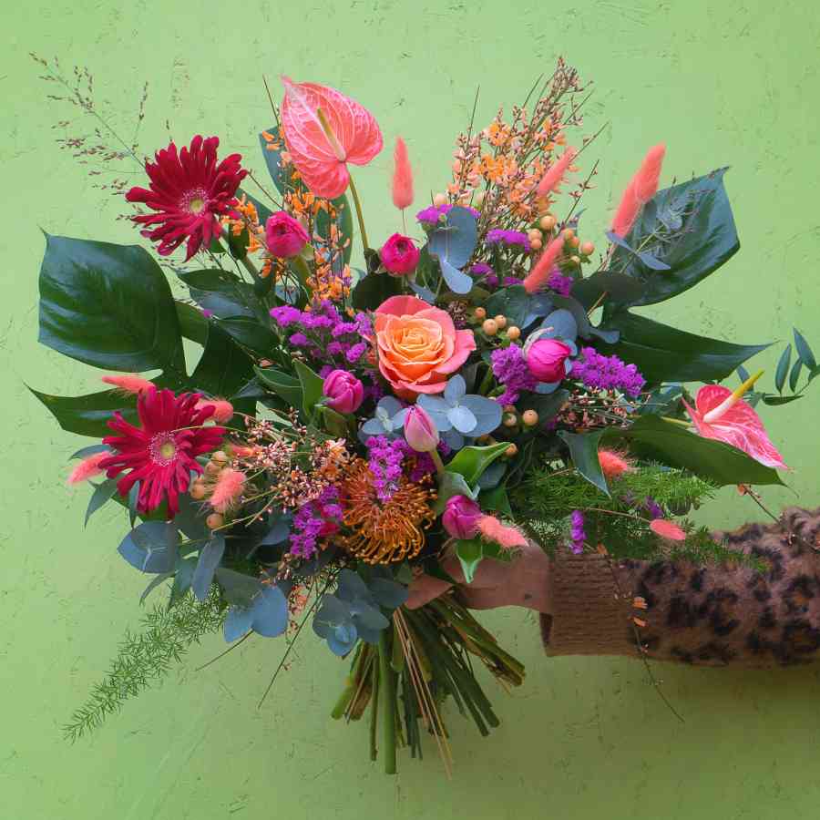 Roses, ranunculus, limonium, genista, anthurium, grasses and textured foliage