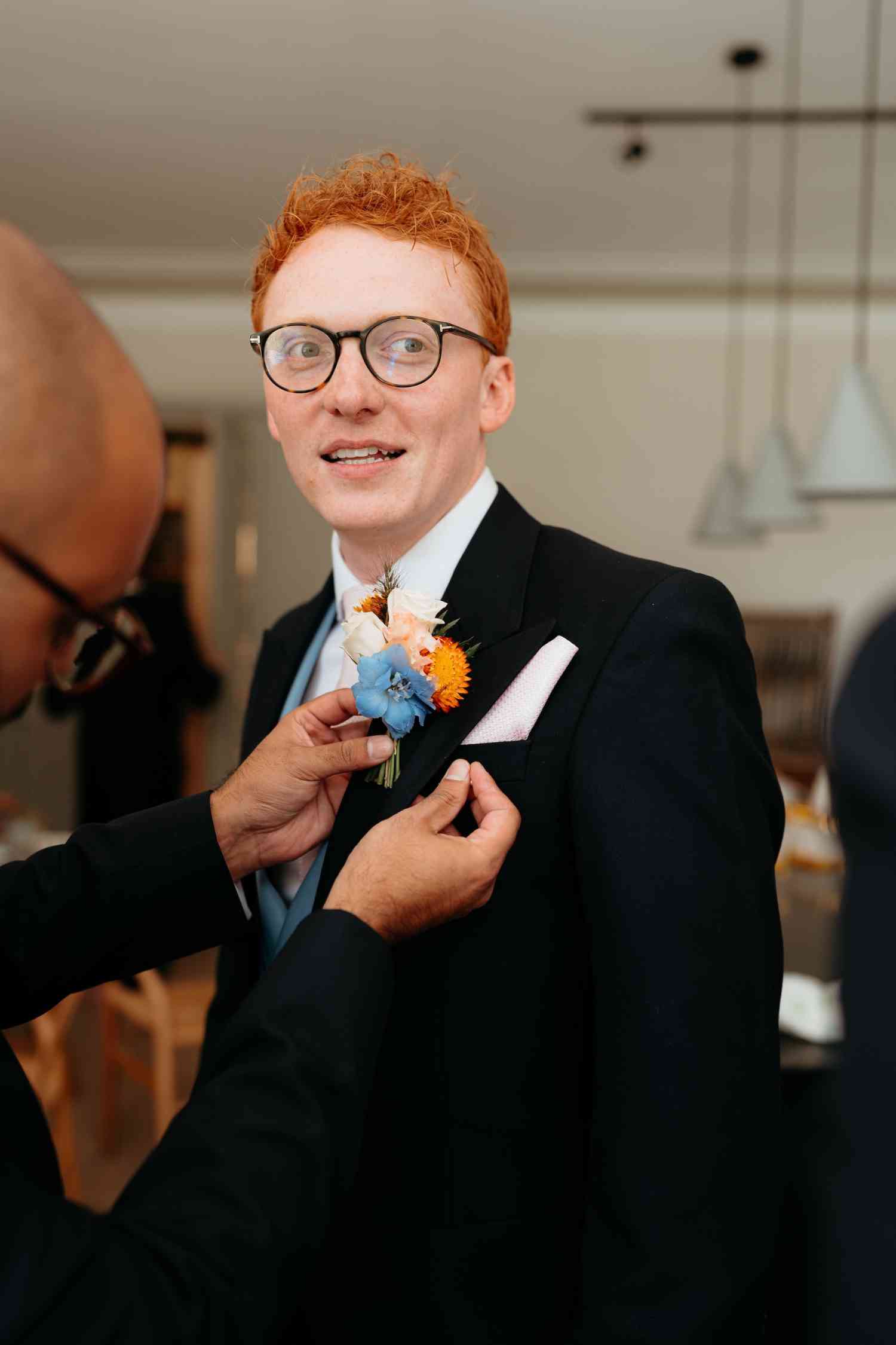 Groom buttonhole orange craspedia blue delphinium rose wedding flowers copy