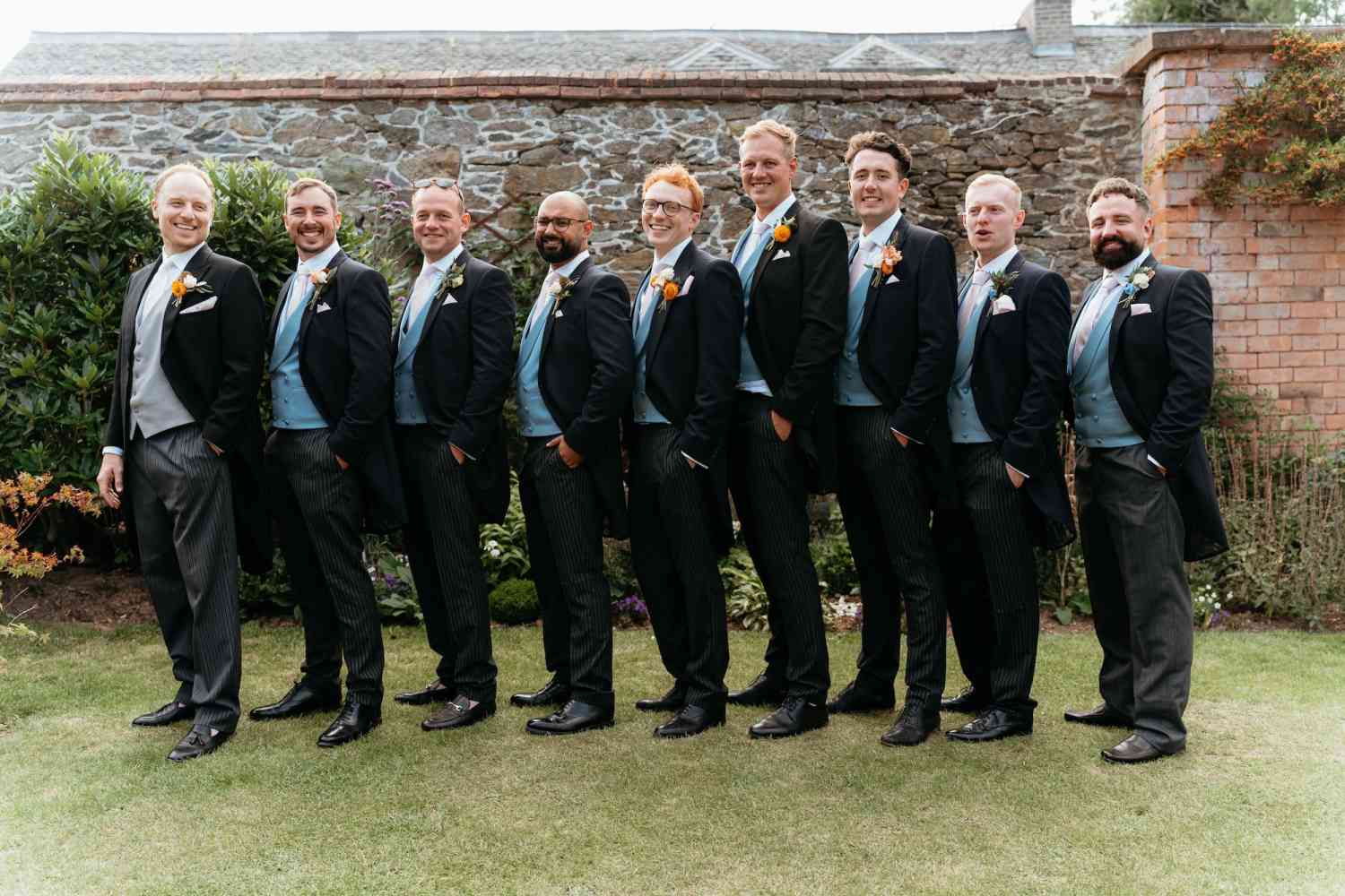 Groomsmen buttonholes orange rose blue delphinium wedding party copy