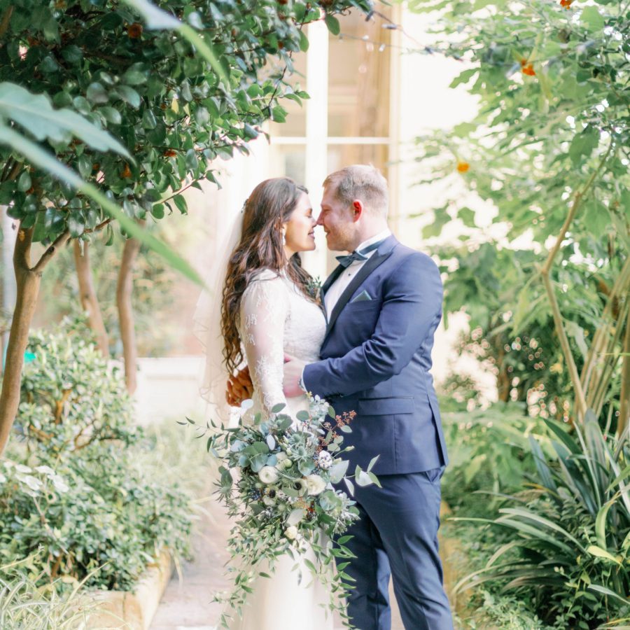 Bride and groom at Prestwold Hall holding green and white bridal bouquet