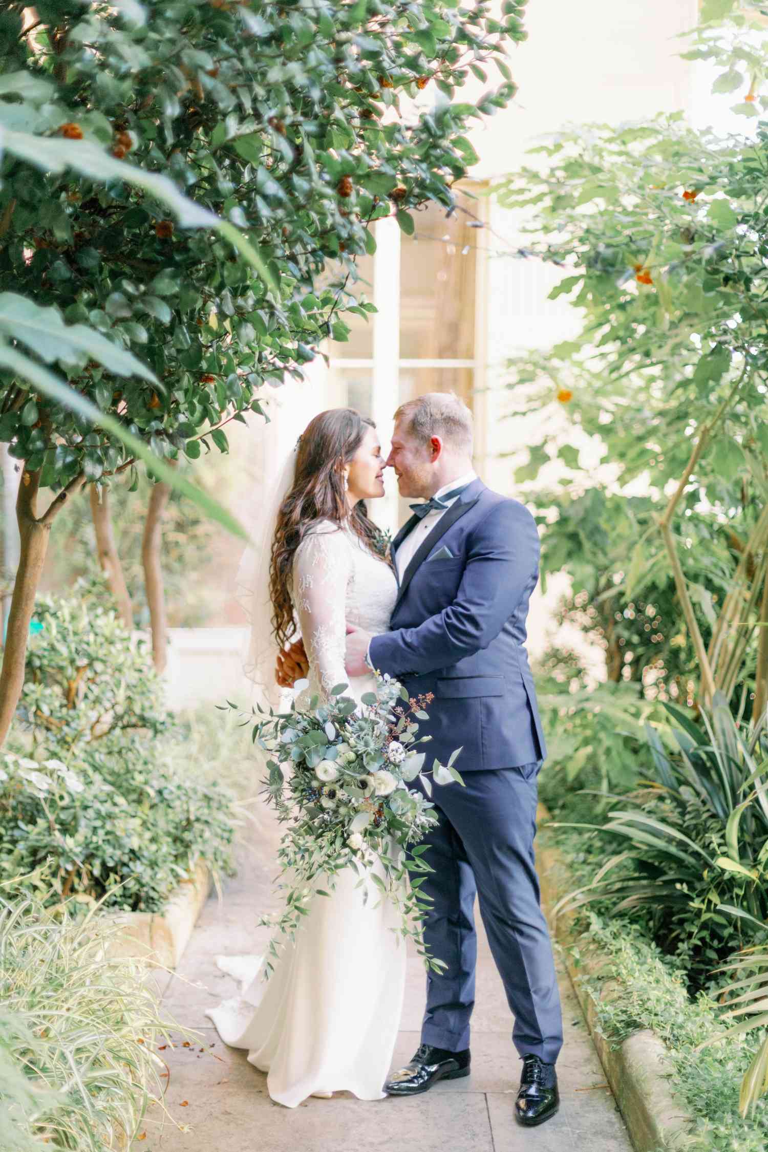 Bride and groom at Prestwold Hall holding green and white bridal bouquet